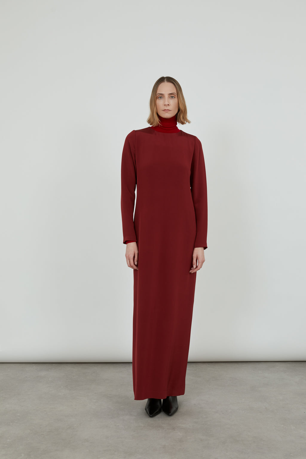 Woman wearing a long red Abelun dress in crepe silk