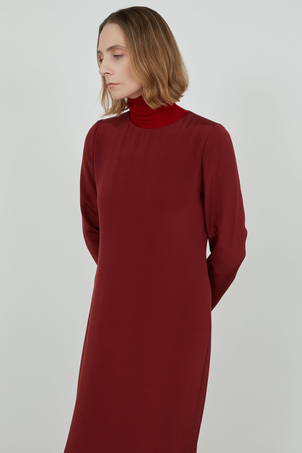 Woman wearing a red Abelun dress in crepe silk, detail of the dress