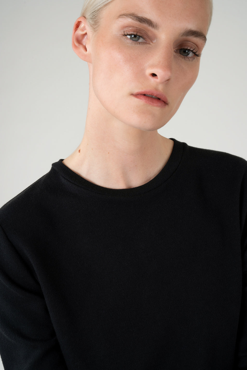 Detailed view of a woman wearing a black longsleeve top.
