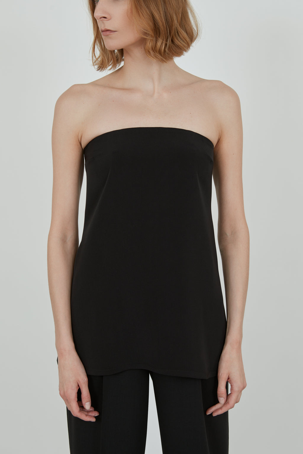 Detail of a woman wearing a black strapless top.