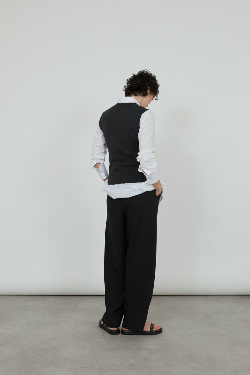 Emma knitted sleeveless top over a white shirt ad black tailored trousers. 