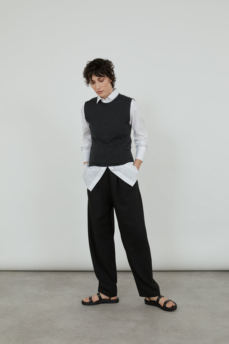 Emma knit in Dark Grey over a white shirt with black tailored trousers. 