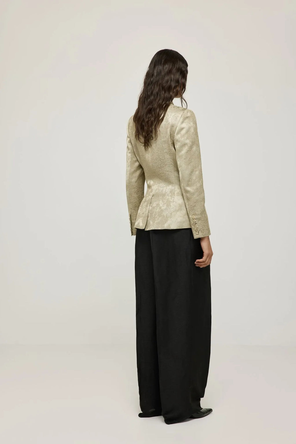 Back view of the Margaret gold blazer, showing its shaping through the waist.