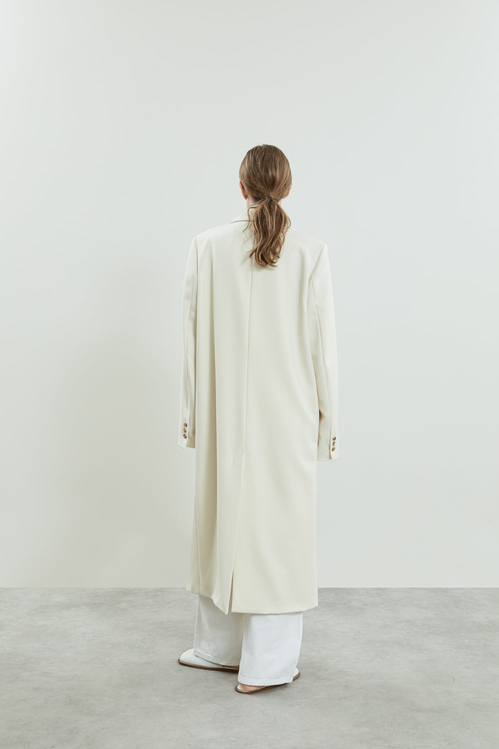 Off white Achilles coat with a oversized collar and a sleek split at the back.