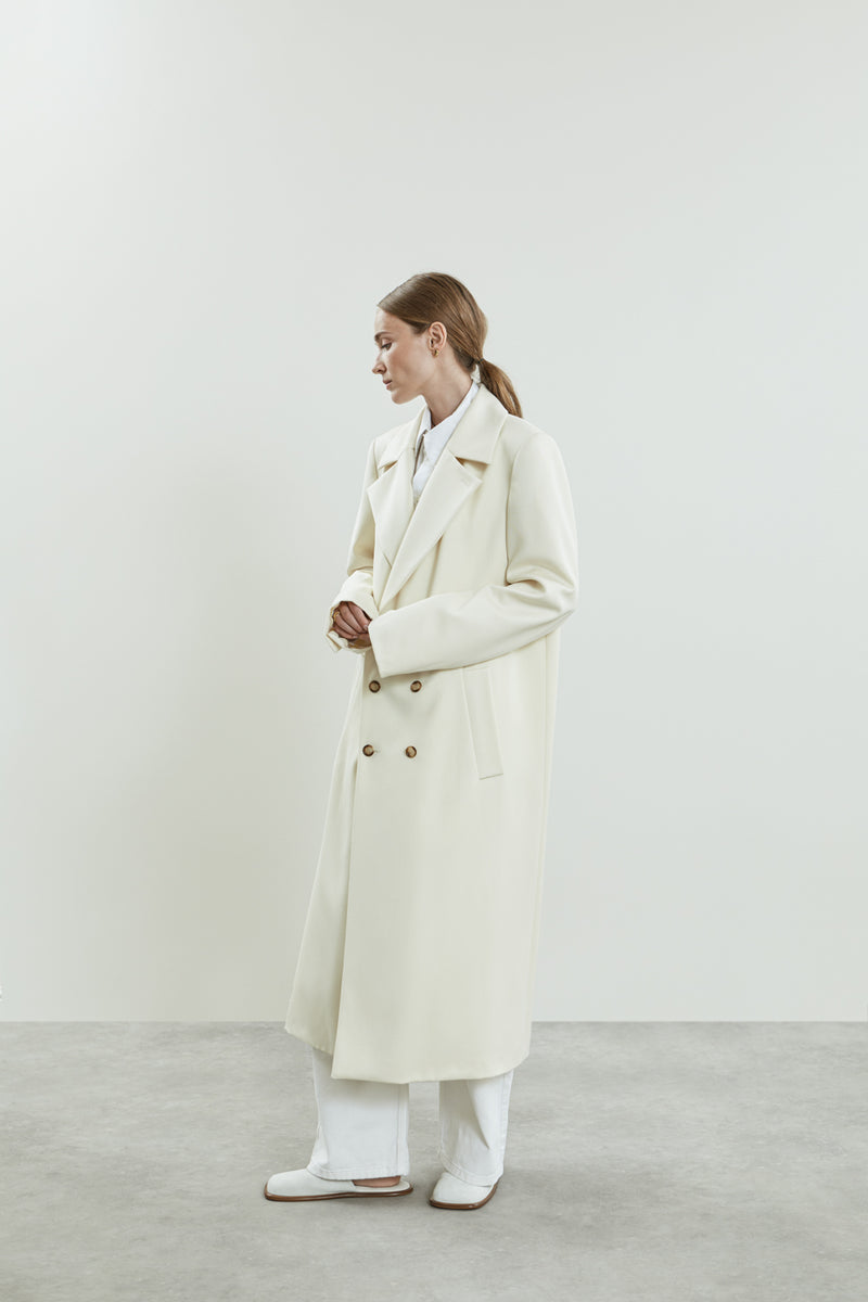 Side front of off white Achilles coat with long sleeves.