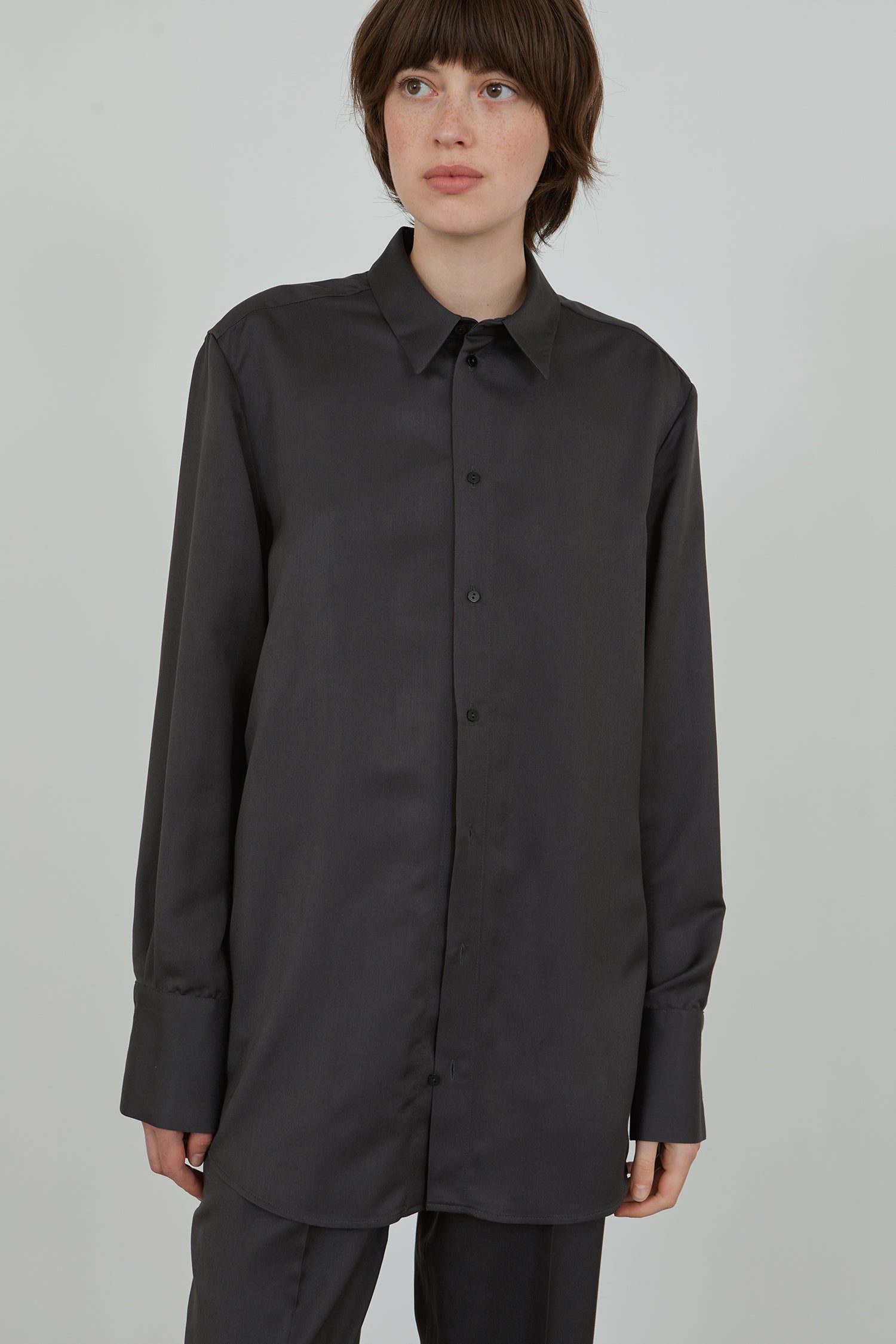 Detail of woman wearing aubergine grey viscose shirt and trousers.