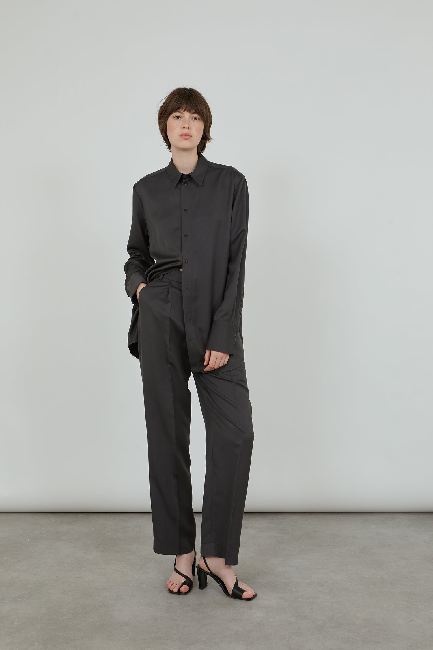 La Collection aubergine grey shirt in soft viscose and trousers with black leather sandals.