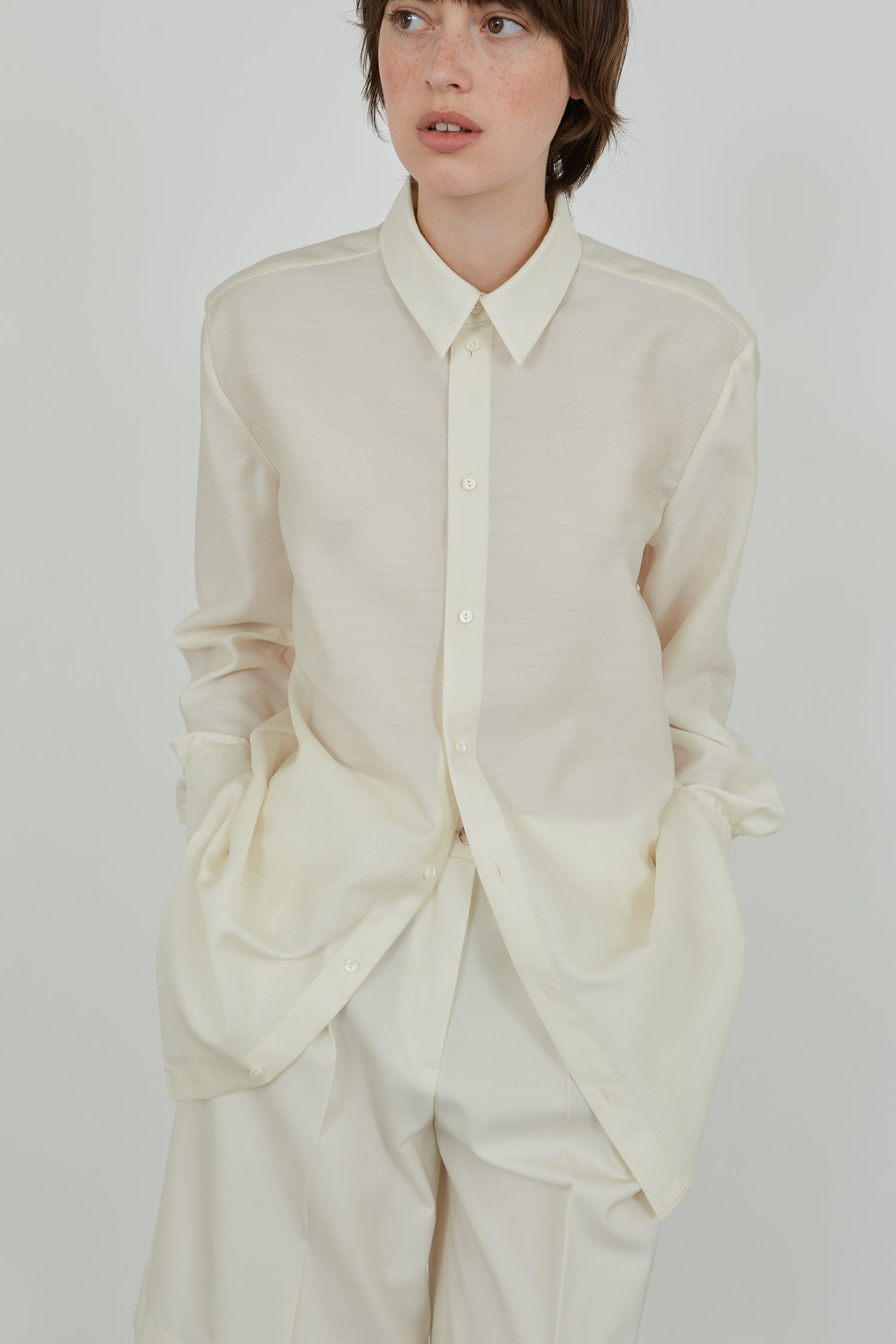 Detailed view  of an ivory long sleeved shirt in a crisp wool silk blend.