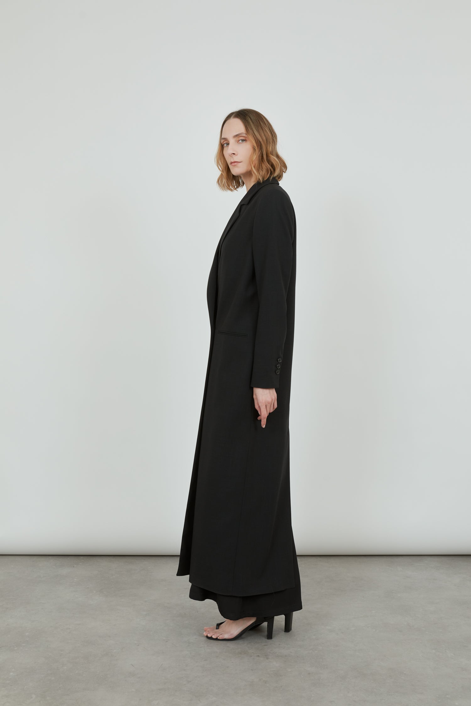 Black virgin wool long coat from the side