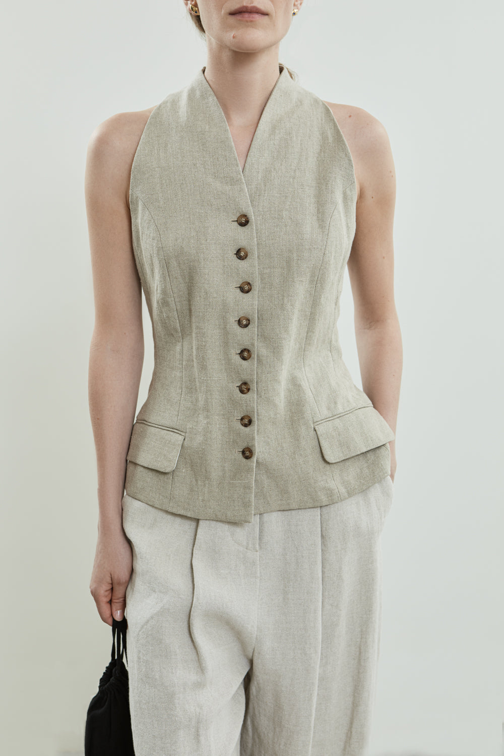 Front view of the Akari gilet in beige linen, showcasing its structured neckline.