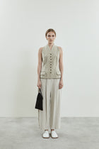 Front view of the Akari gilet in beige linen, showcasing its structured neckline.