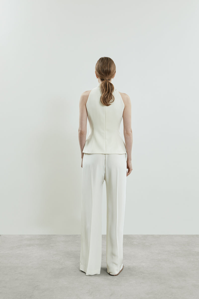 Back view of the off-white Akari gilet in virgin wool, emphasizing its tailored fit and clean lines.