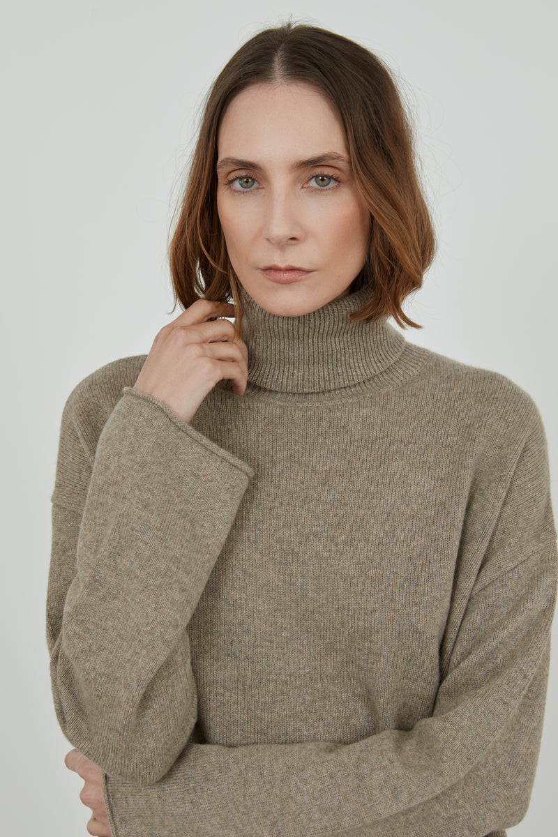 Woman is wearing the biscuit cashmere wool knit sweater.