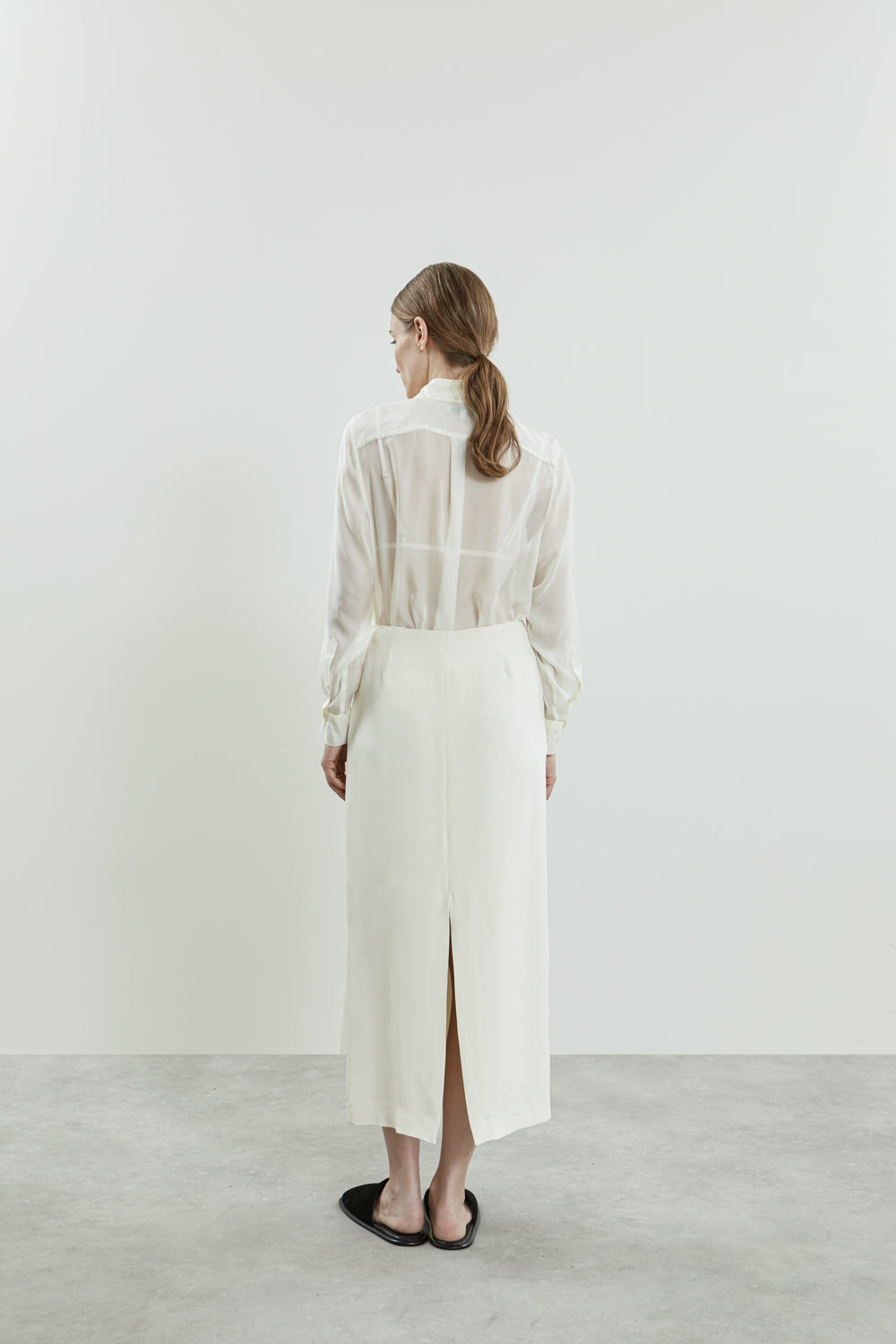 Back view of the Off white crepe silk skirt, emphasizing the clean lines, fluid silhouette.