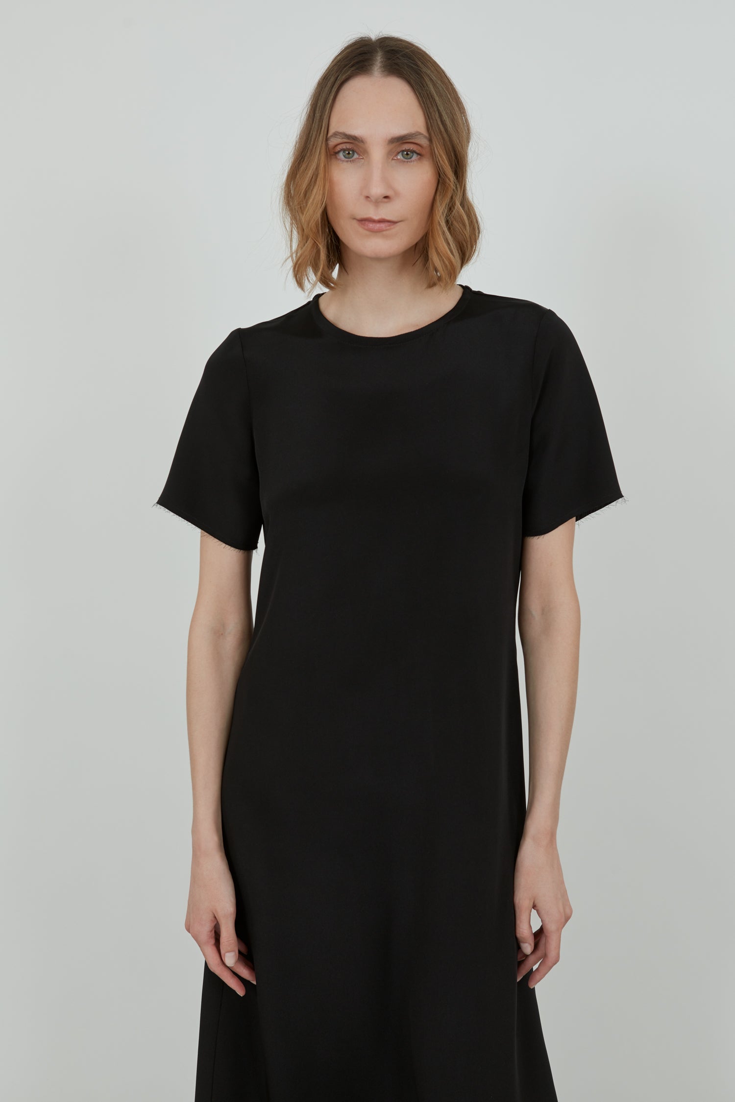 Close-up of the raw hem on the sleeves of the black Celine dress.