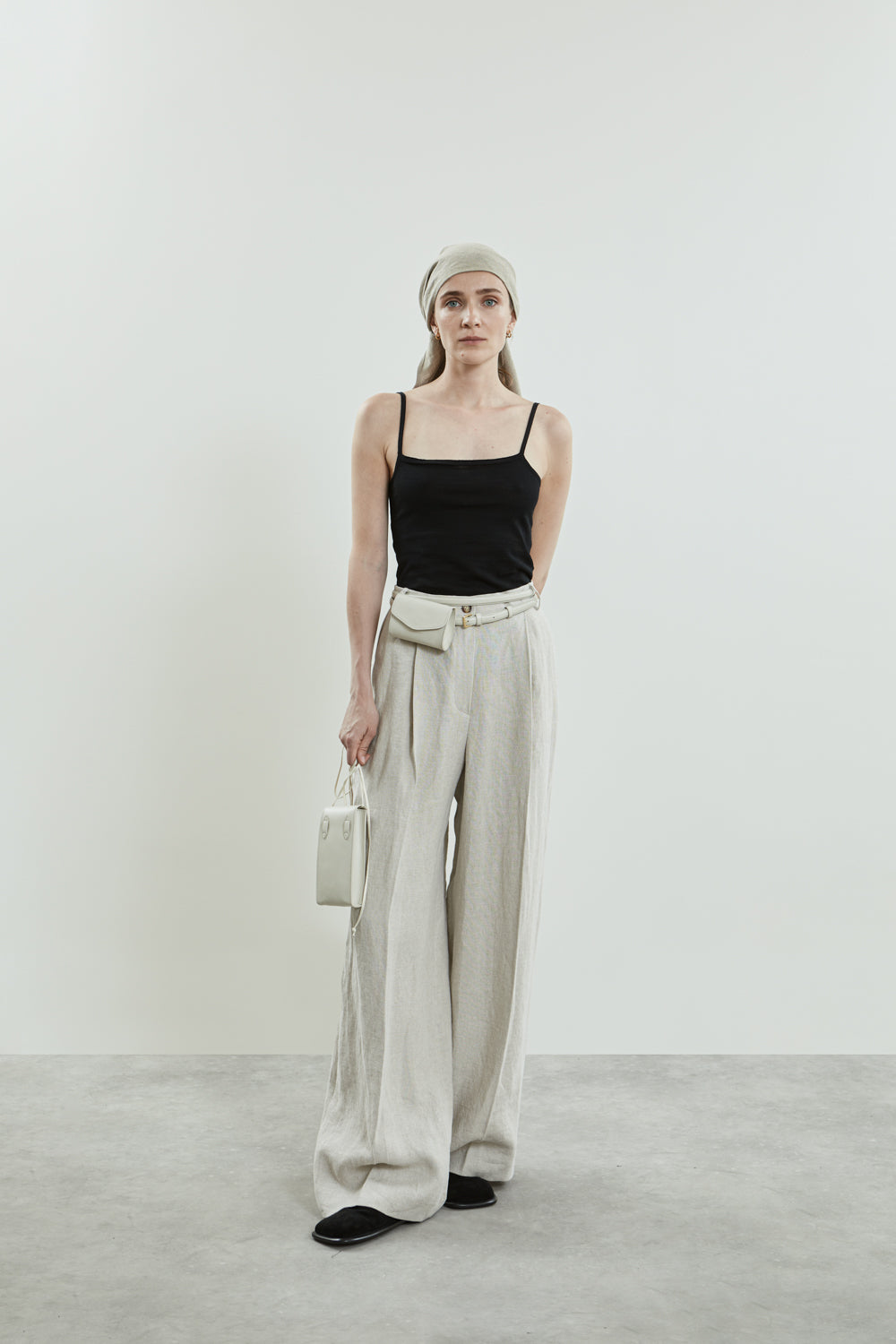 Full-length view of the beige Dalida trousers. Combination with luca wallet bag en ita phone bag.