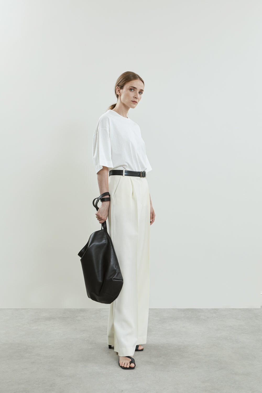 Full-length view of the off-white Dalida trousers, high waist and pockets.