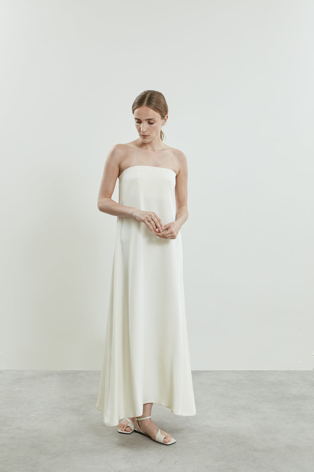 Front view of the of white Joan dress in crepe silk, featuring open shoulders and a sleek silhouette.