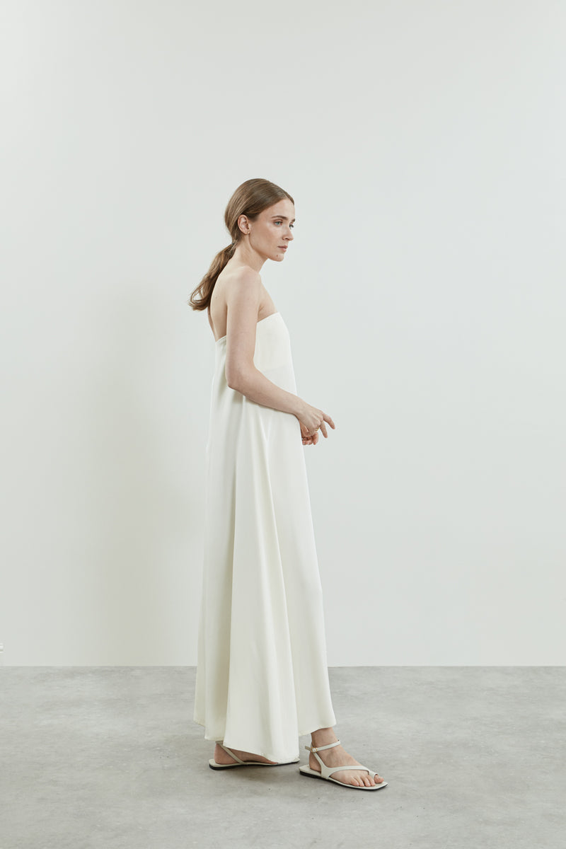 Side view of the off white Joan dress in crepe silk, showcasing the open shoulder detail.