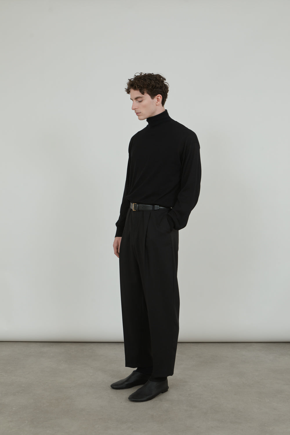 Side view of the black Julien knitted turtleneck.