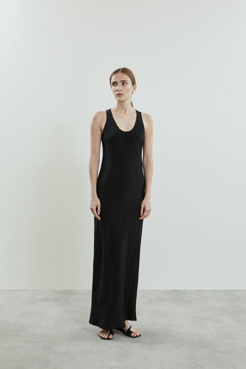 Side view of the black Kate dress in crepe silk, showcasing the sleek, form-fitting silhouette, clean scooped neckline, and smooth silk fabric.