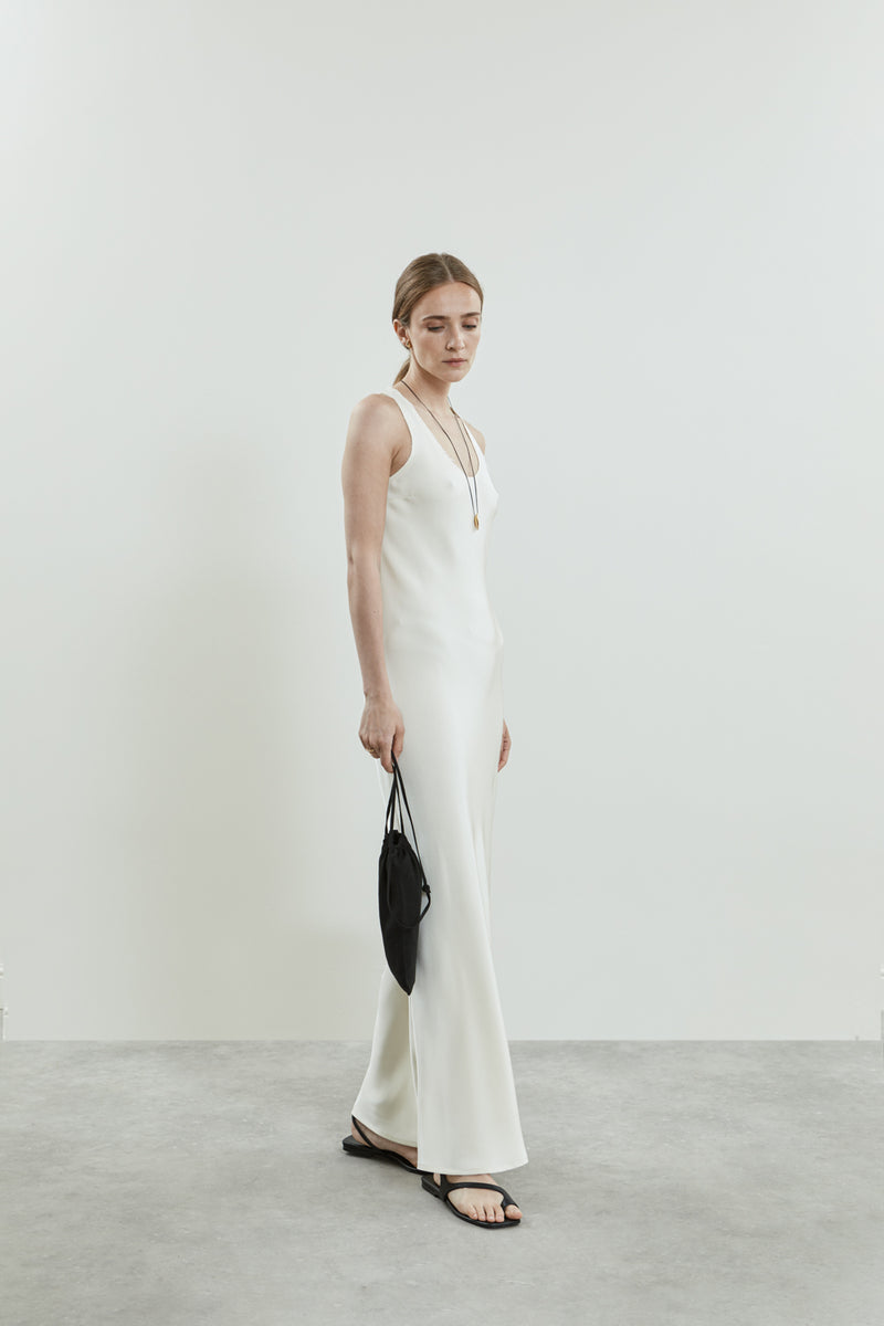 Side view of the off-white Kate dress in crepe silk, showcasing the sleek, form-fitting silhouette, clean scooped neckline.