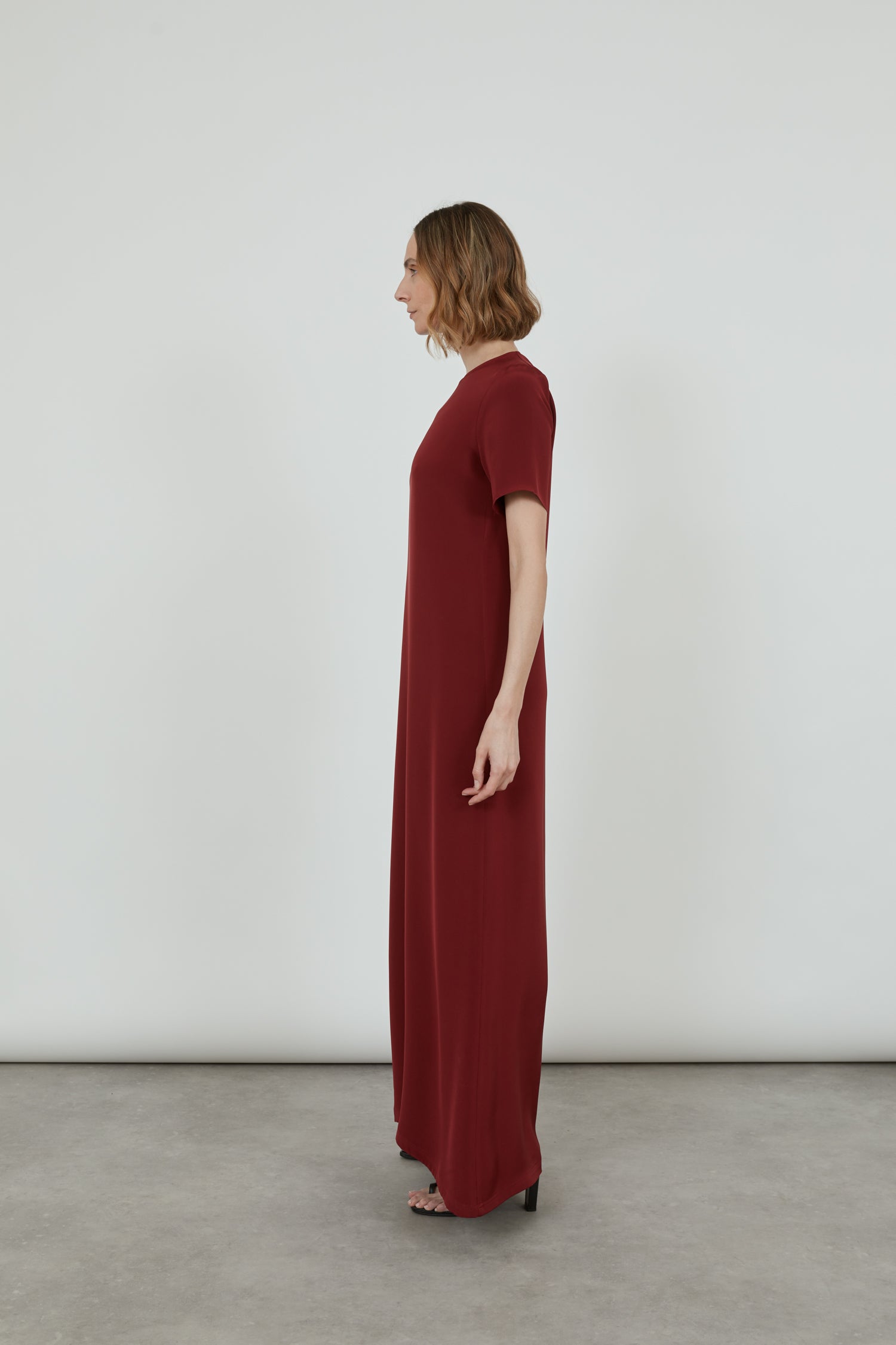 Side view of the red Celine dress, highlighting its ankle-length design.