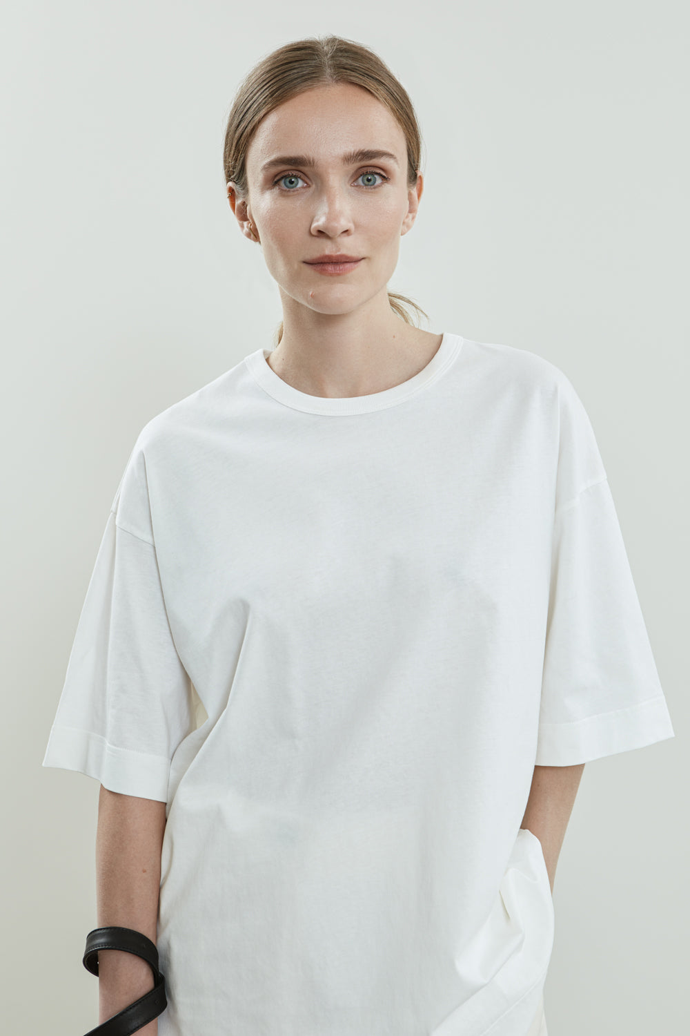 Full-length view of the white Lou T-shirt in cotton jersey, designed with a boxy fit, dropped shoulders, and above-the-elbow sleeves.