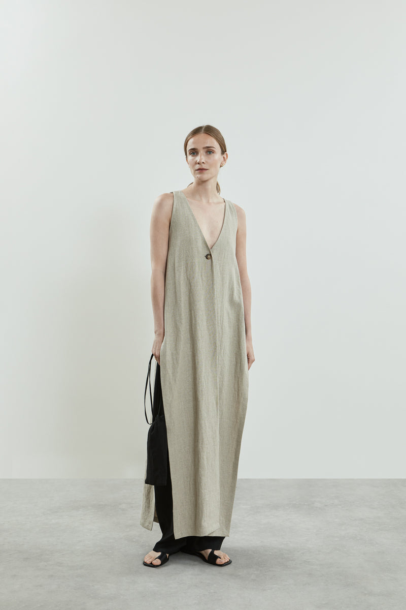 Front view of the beige Louise dress in linen, featuring a sleeveless design, clean lines, breezy silhouette, deep V-neckline, and a single button closure.