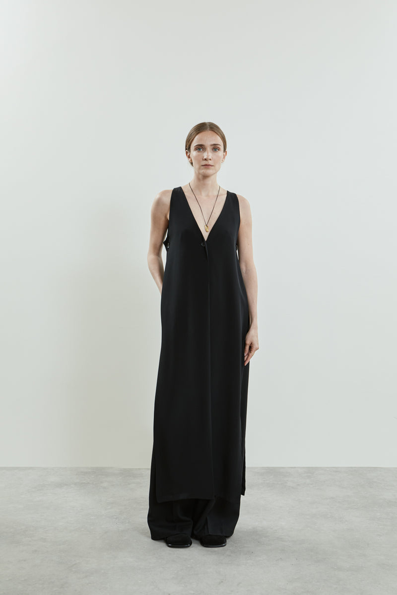 Front view of the black Louise dress in crepe silk, featuring a sleeveless design, clean lines, breezy silhouette, deep V-neckline, and a single button closure.