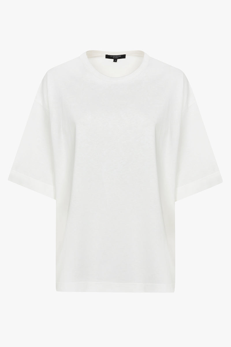 Close-up of the white cotton jersey fabric and crew neckline of the Lou T-shirt, the relaxed design with dropped shoulders and above-the-elbow sleeves.