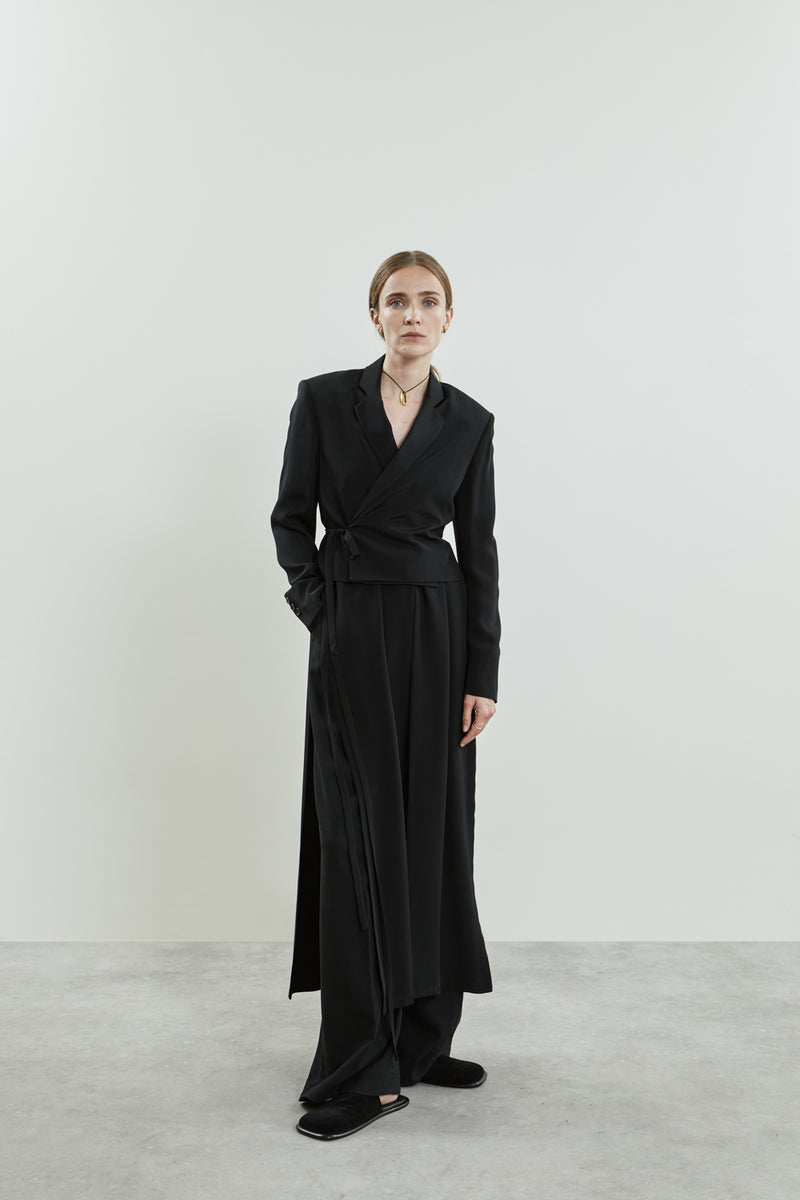 Front view of the Lynn blazer in black crepe silk, featuring a wrap-style tie at the waist, notched lapels.