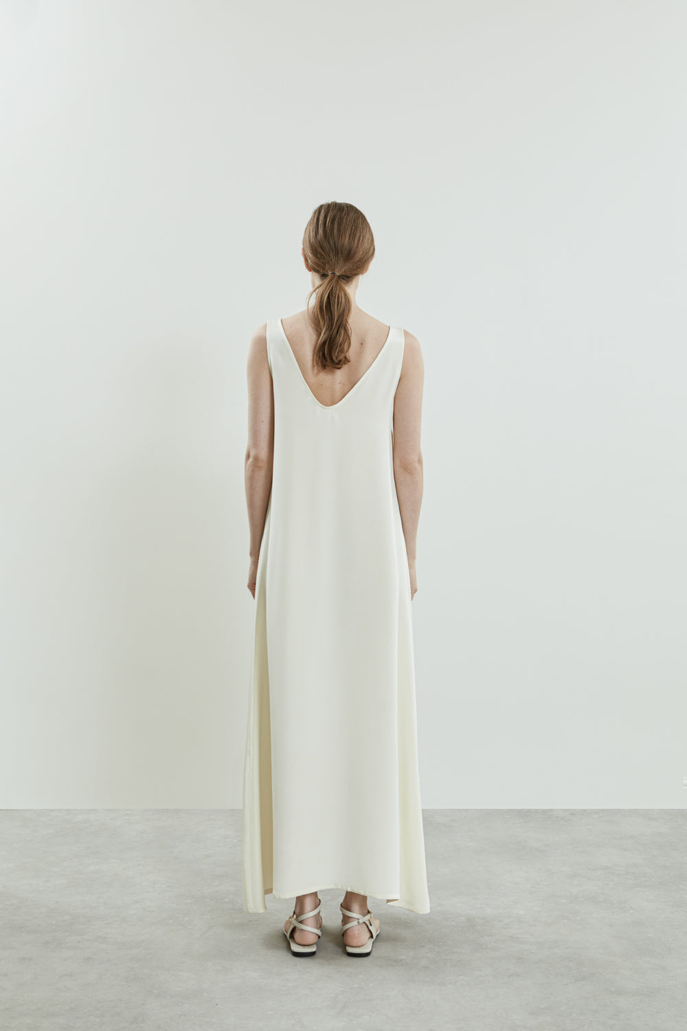 Front view of the Quinn dress in off white crepe silk, featuring a graceful A-line silhouette and a floor-length design.