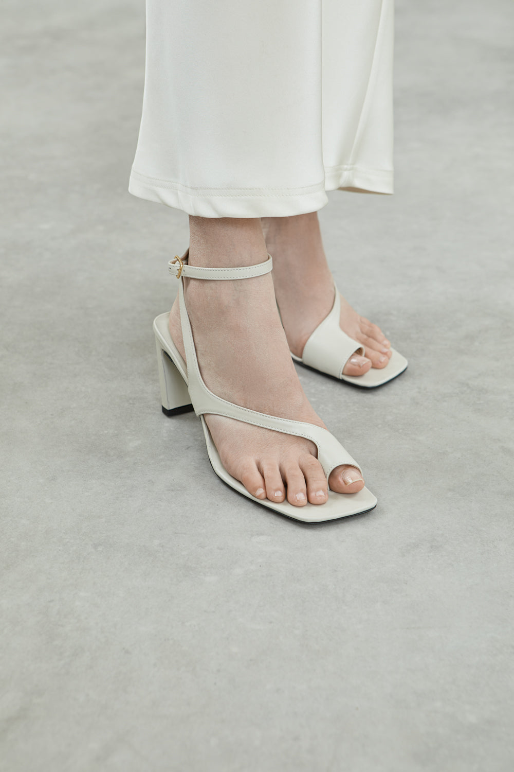 Side view of the Rosie sandals in cream leather, featuring square toes, toe loops, and a chic ankle strap.