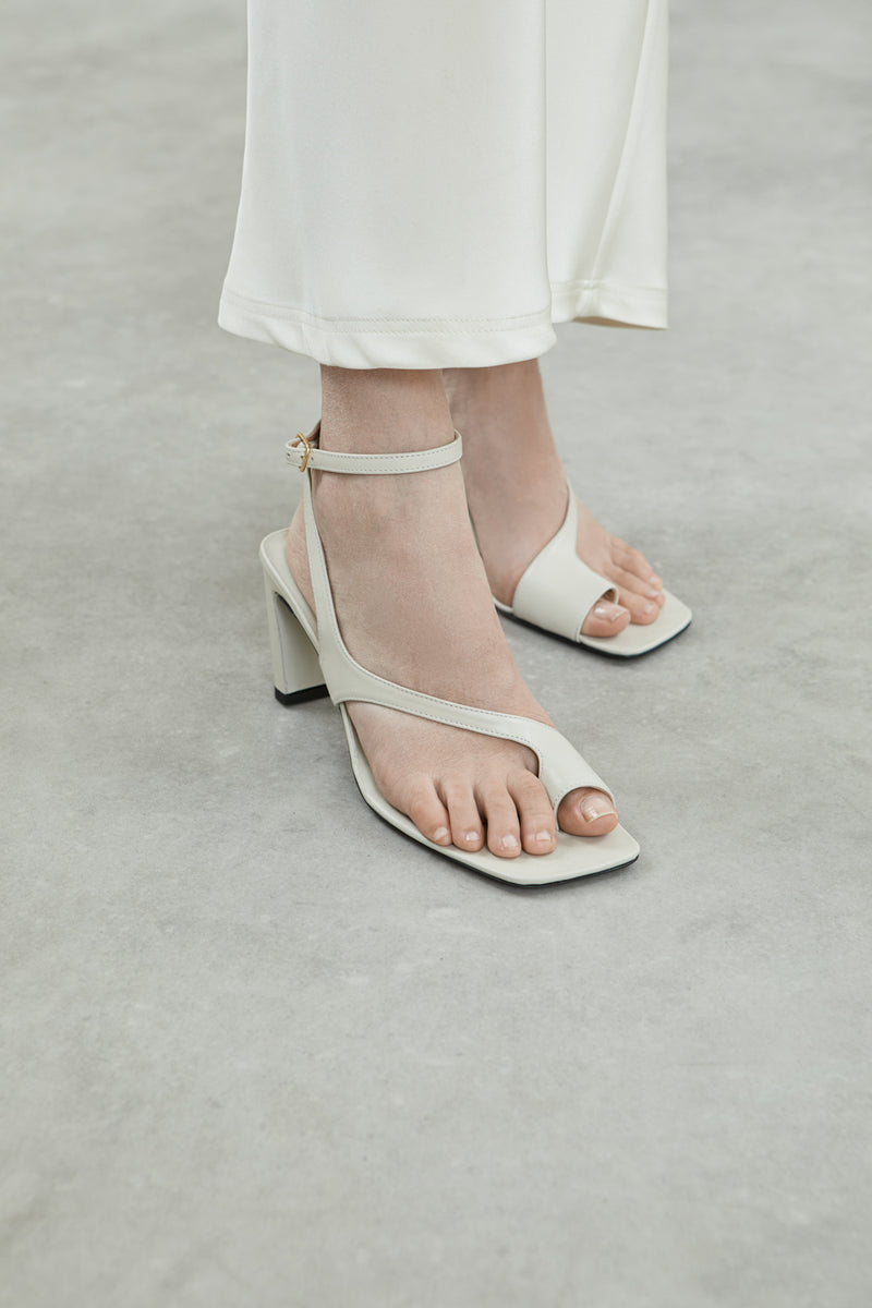 Side view of the Rosie sandals in cream leather, featuring square toes, toe loops, and a chic ankle strap.