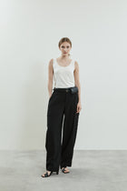 Front view of the Stein trousers in black virgin wool, highlighting the high waist, oversized patch pockets, and adjustable hem tabs.