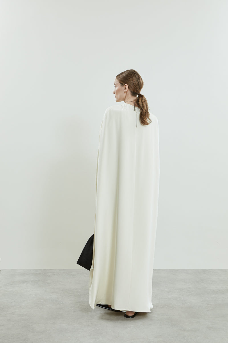 Back view of the Ursula cape in off white crepe silk, emphasizing the effortless drape.