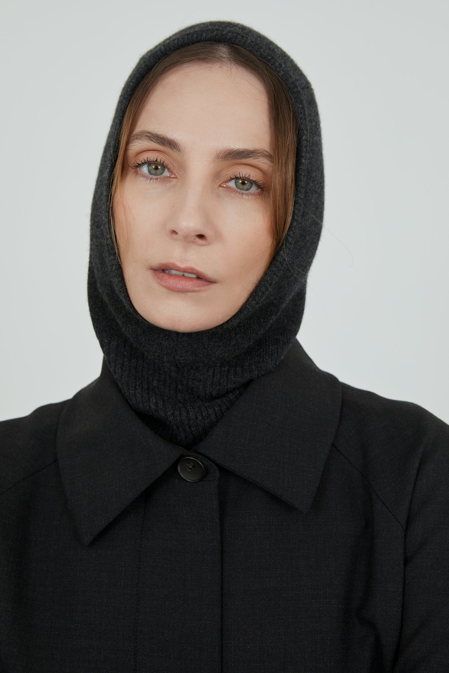 Dark grey Cathy balaclava in merino wool combined with a dark grey coat.